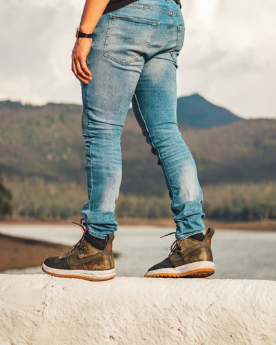 People wore blue denim jeans and brown hiking shoes
